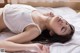 A woman laying on a bed with her eyes closed.