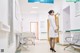 A woman in a white lab coat standing in a hospital hallway.